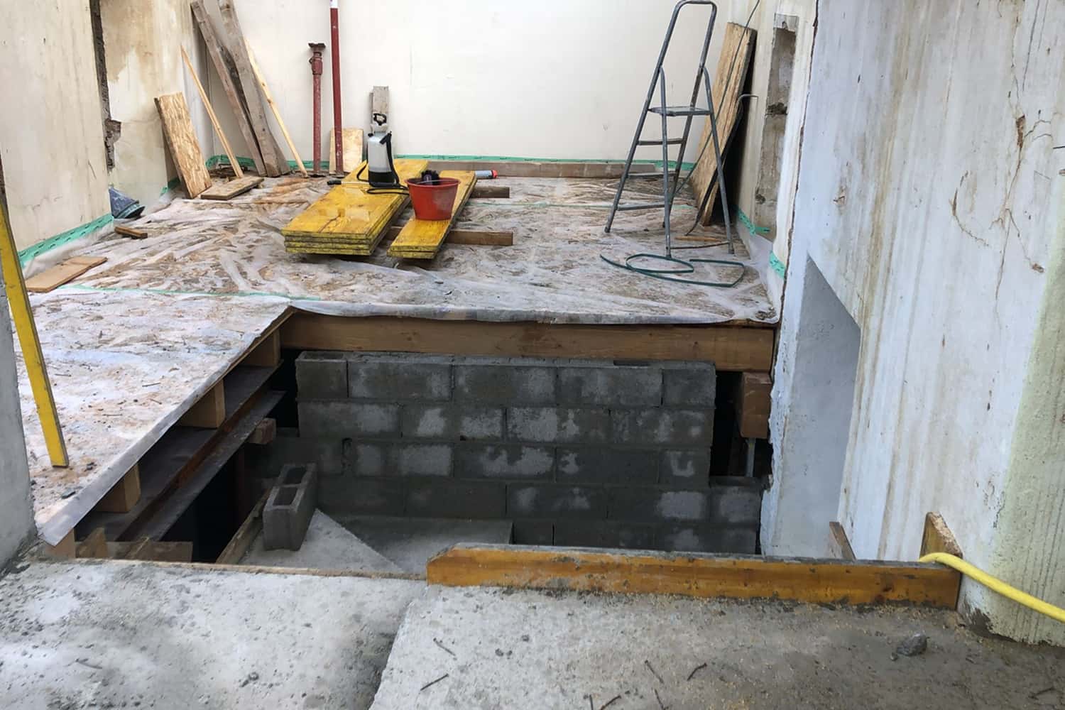 Cantiere di una nuova costruzione: attrezzi, mattoni e travi di legno